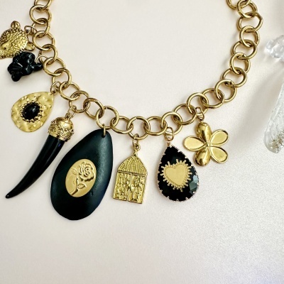 Colar dourado com pendentes decorativos em preto e dourado