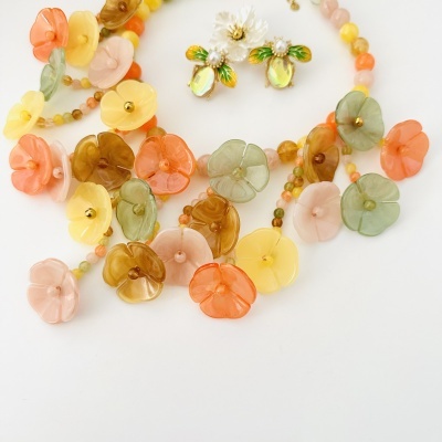 Colar de flores coloridas e brincos em forma de abelha com flor branca