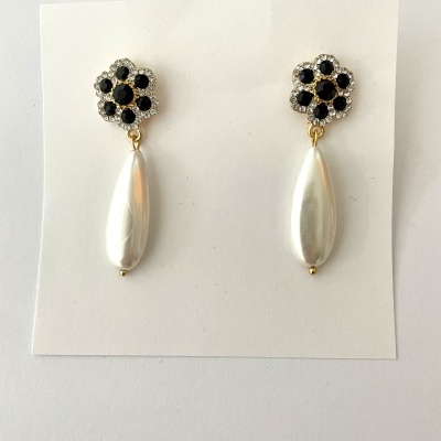 Brincos flor com pedra preta e pérola gota pendente em cartão branco
