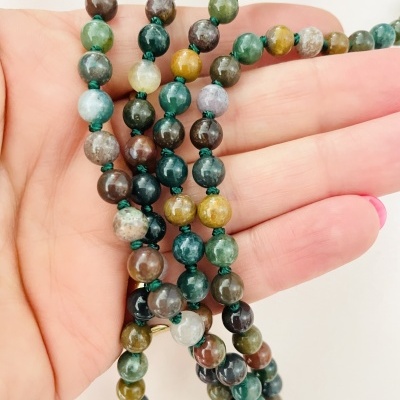 Colares ou pulseiras com contas coloridas em mãos