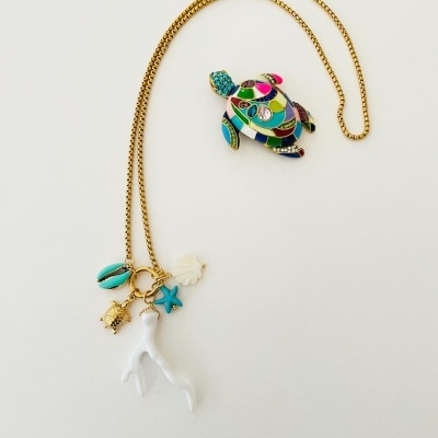 Colar dourado com pendentes coloridos de tartaruga, estrela-do-mar, concha, coral e vestido