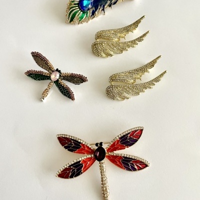 Broches variados com pedras coloridas e metal sobre fundo branco