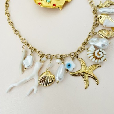 Conjunto de colar e broche com conchas e estrelas do mar em metal dourado e pérolas