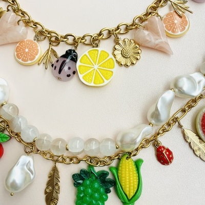 Colares com pendentes de frutas, flores, folhas e contas em correntes douradas