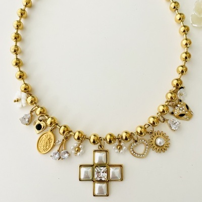 Colar dourado com pendentes variados sobre fundo branco