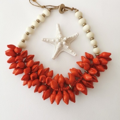 Colar com contas brancas e vermelhas em forma de gotas com fecho de botão em madeira junto a estrela-do-mar branca