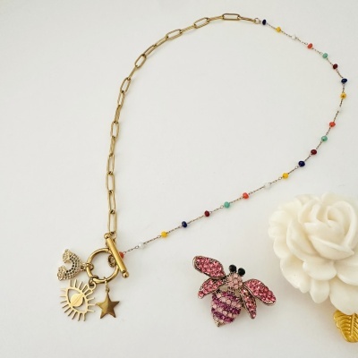 Colar dourado com pendentes coloridos e flor branca