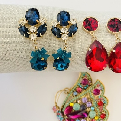 Brincos pendentes azuis e vermelhos e borboleta decorativa com pedras coloridas