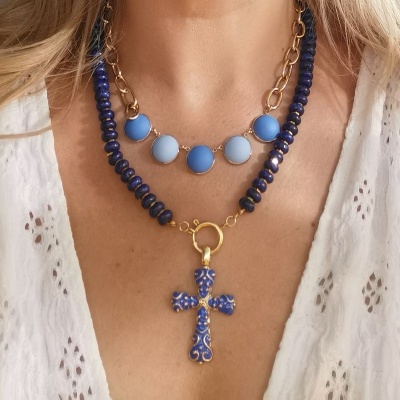 Colar duplo azul com pingente de cruz dourada e azul em pessoa com camisa branca