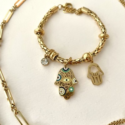 Pulseira dourada com pingentes da mão de Fátima em fundo branco