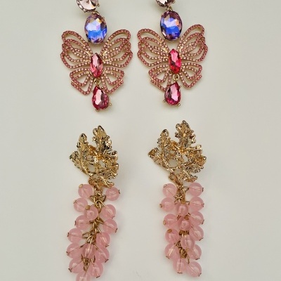 Dois pares de brincos dourados com pedras rosa e azul em fundo branco