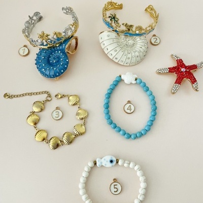 Joias com conchas coloridas, braceletes e pulseiras de contas em fundo claro