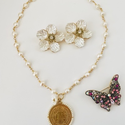 Colar de pérolas com medalhão, brincos florais prateados e broche de borboleta com pedras coloridas