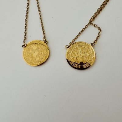 Colares dourados com pendentes redondos gravados religiosamente em fundo branco