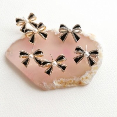 Conjunto de brincos laço com esmalte preto e pérola sobre pedra rosa