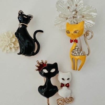 Broches gatos preto, branco e amarelo com detalhes e flores brancas