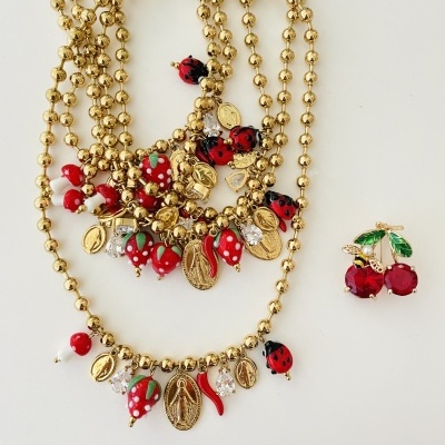 Conjunto de colares dourados com pendentes coloridos e brinco de cerejas