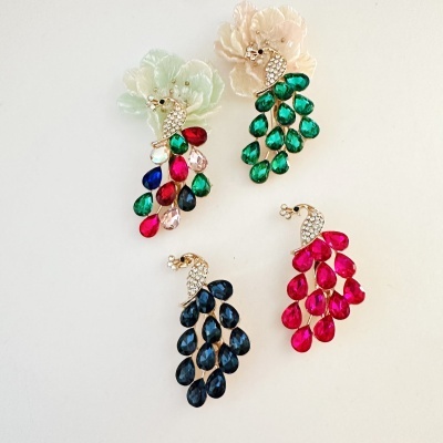 quatro brincos de pavão com pedras coloridas e flores decorativas