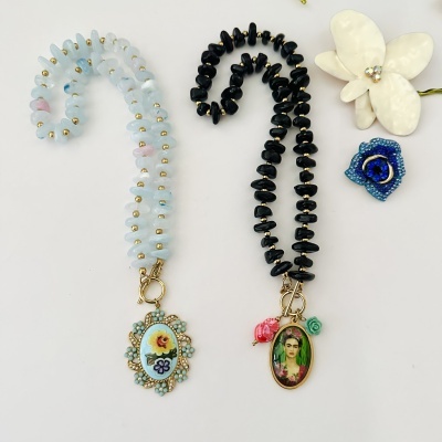 Dois colares de contas com pendentes sobre fundo branco.