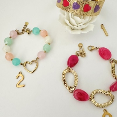 Pulseiras coloridas e douradas com pendentes em fundo branco
