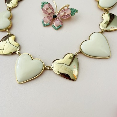 Colar de corações brancos e dourados com broche de borboleta colorida