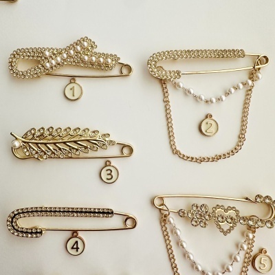Conjunto de 5 alfinetes dourados com cristais e pérolas e pendentes numerados