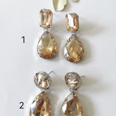 Dois pares de brincos pendentes com pedras castanhas claras em fundo branco