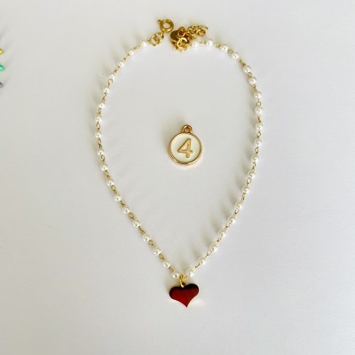 Colar de pérolas com pendente de coração vermelho e pendente redondo com número 4.