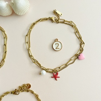 Pulseira dourada com vários pendentes coloridos e medalha com número 2