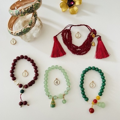 Seis peças de bijuteria numeradas, incluindo braceletes, pulseiras de contas coloridas e broche dourado floral