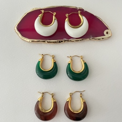 Três pares de brincos de argola dourados com detalhes coloridos em branco, verde e castanho