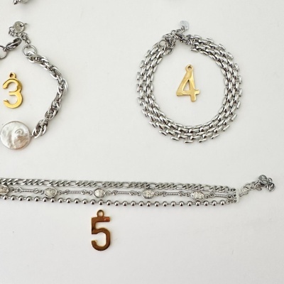 Pulseiras com pendentes dourados de números 3, 4 e 5