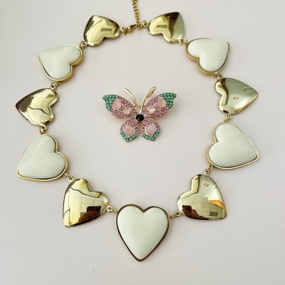 Colar de corações dourados e brancos com broche de borboleta colorida