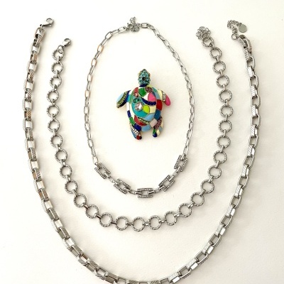 Três correntes prateadas e pingente colorido de tartaruga