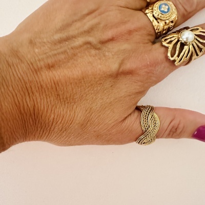 Mão com três anéis dourados distintos, fundo branco