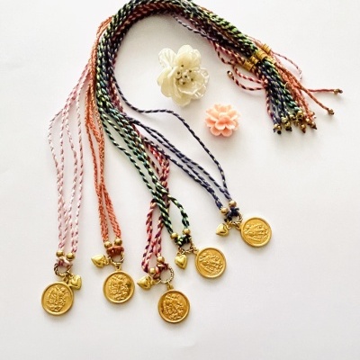 Colares coloridos com pendentes dourados e flores decorativas