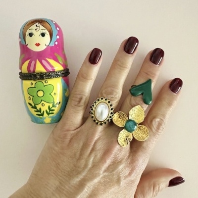 Mão com três anéis e caixa de boneca russa colorida