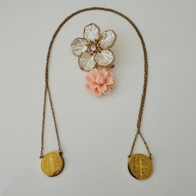 Colar dourado com pendentes redondos e broche de flor com pétalas brancas e flor cor de rosa em tecido