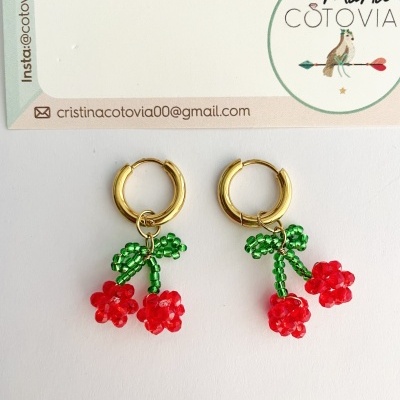 Brincos dourados com pendente de cerejas vermelhas e verdes em contas