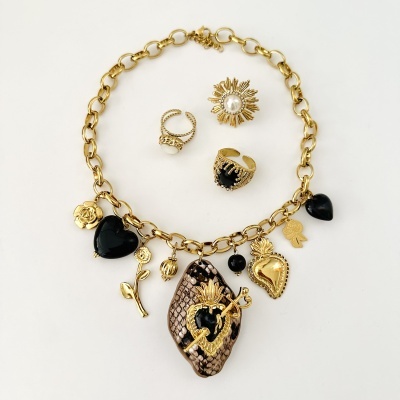 Colar dourado com pendentes e anéis dourados com pedras pretas e pérola