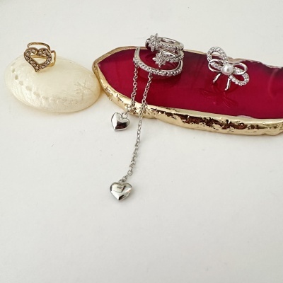 Anéis e brincos em metal com pedras e pérola sobre pedras decorativas