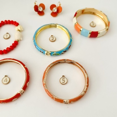 Conjunto de brincos, pulseiras e bracelete coloridos em fundo branco