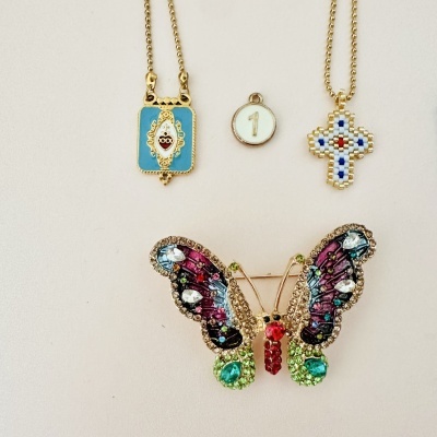 Colares e broche coloridos com pedras e padrões variados sobre fundo claro