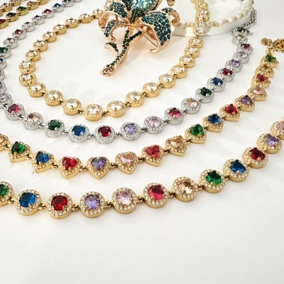 Colares de metal com pedras coloridas e alfinete decorativo em forma de flor