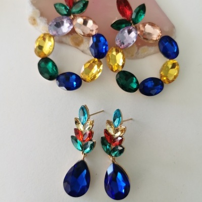 Dois pares de brincos com pedras coloridas, um circular e outro com gota azul