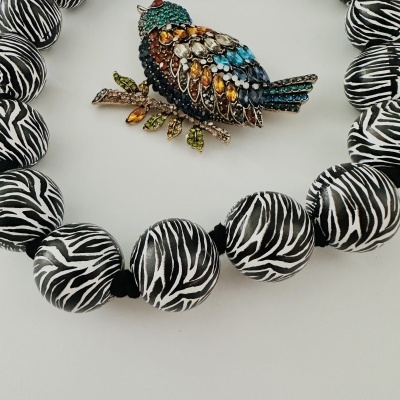 Colar com contas padrão zebra e broche em forma de pássaro colorido