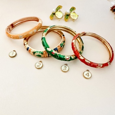 quatro pulseiras coloridas com padrões florais e par de brincos com pérolas sobre fundo claro