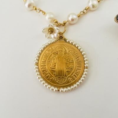 Colar com pendente dourado redondo com figura religiosa e pérolas brancas