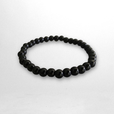 Pulseira de contas pretas em fundo branco