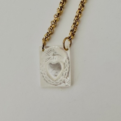 Colar dourado com pendente retangular prateado com coração em relevo